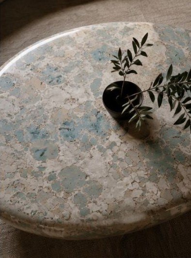 Piano del tavolino con la texture e un vaso con rami di ulivo