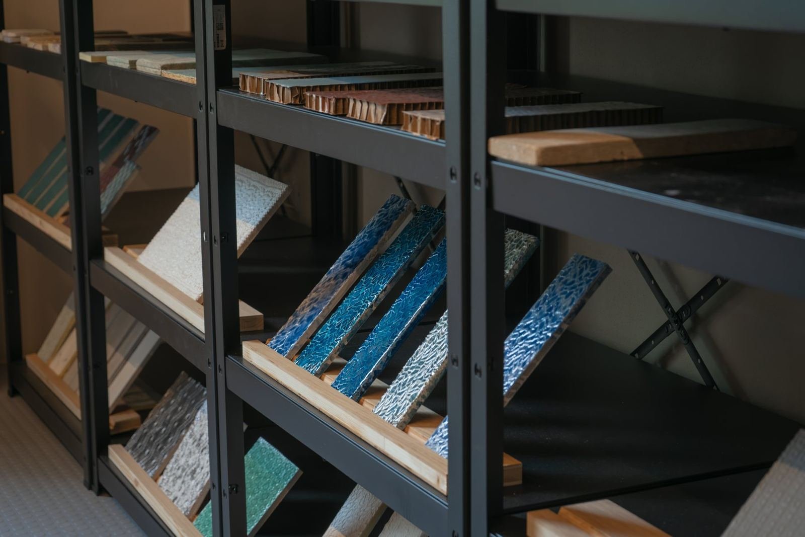 Campioni resinati blu e superfici materiche esposti sugli scaffali del laboratorio